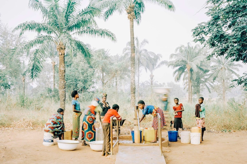 Women and children gather around the water pump in Osukputu in Nigeria.