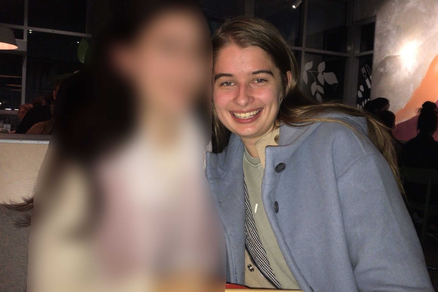 Karly at a restaurant with a friend (blurred)