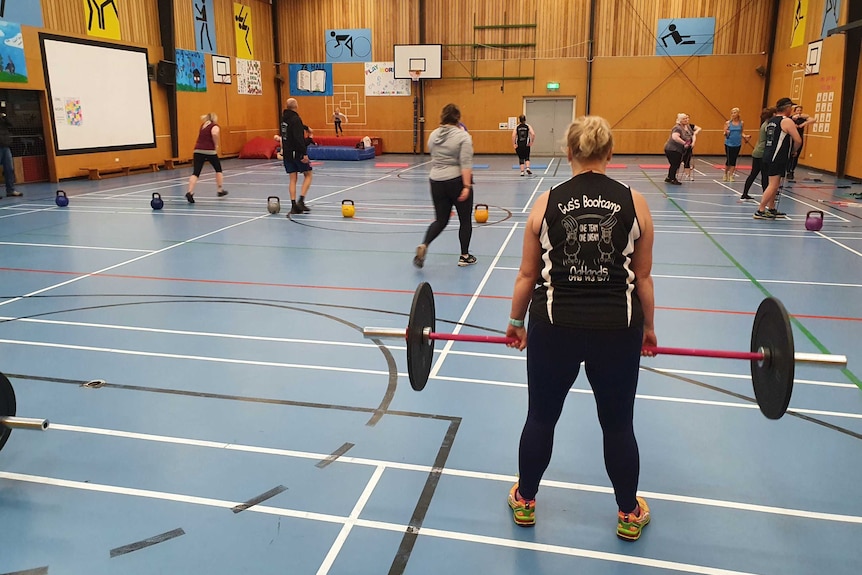 A group of people exercise in a regional hall.