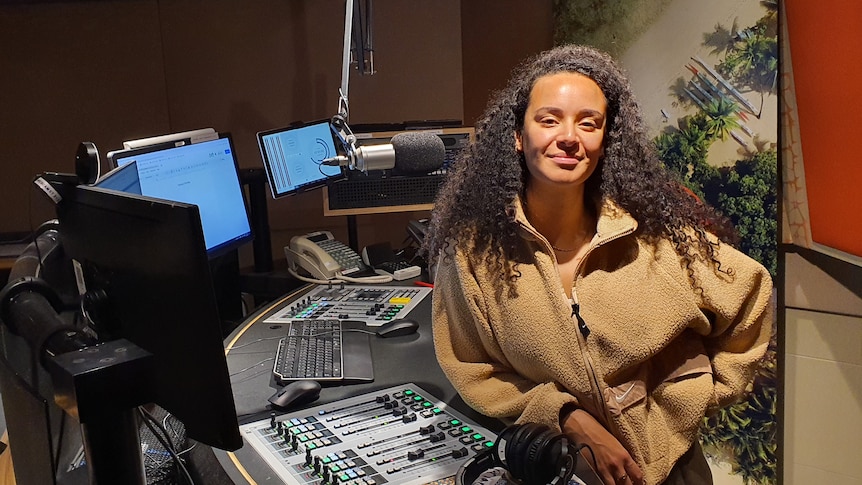 Woman rests against radio panel.