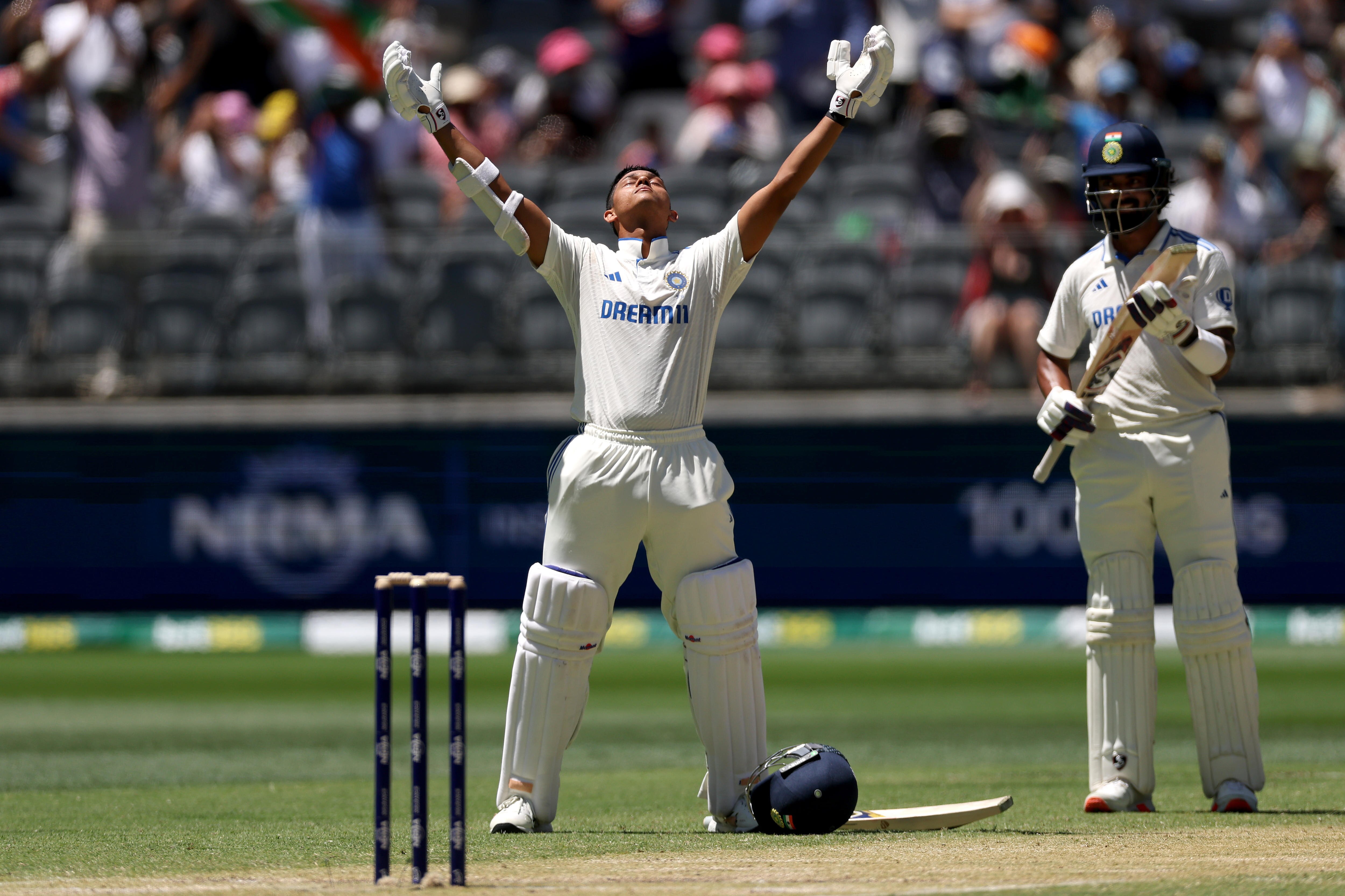 Yashasvi Jaiswal celebrates with his arms aloft after reaching a century
