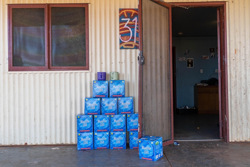 14 boxes of water in front of a house