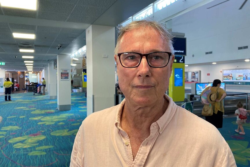 John Bonnin wearing a pale shirt wearing glasses at the airport.