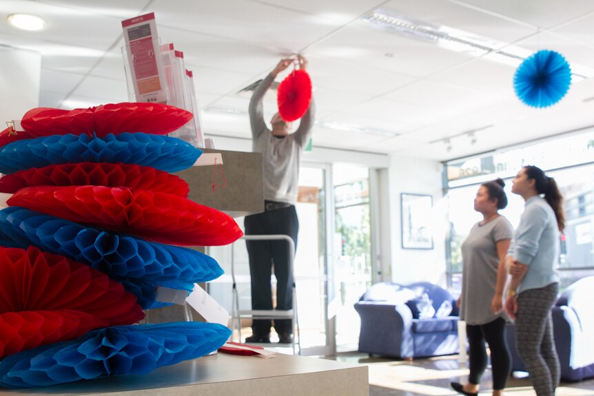 Red, white and blue decorations being hung by students at Alliance Francaise in Brisbane.