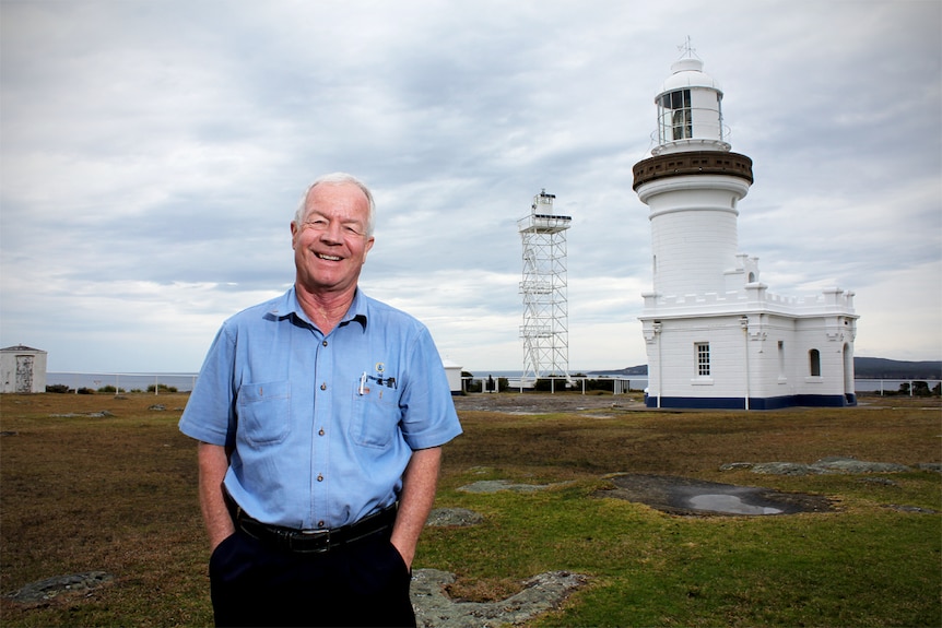 Man stands in front of lighthouse