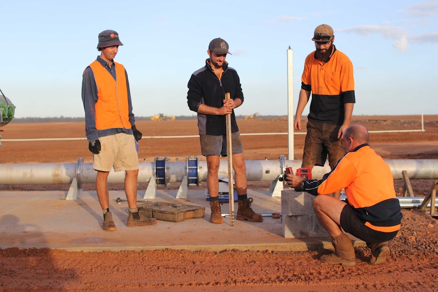 four men working on a bore pad
