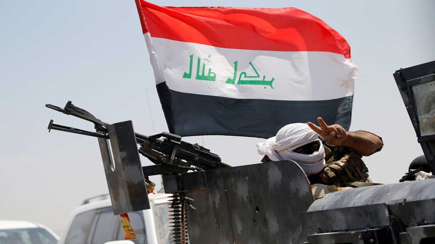Member of Iraqi security forces gestures near Fallujah