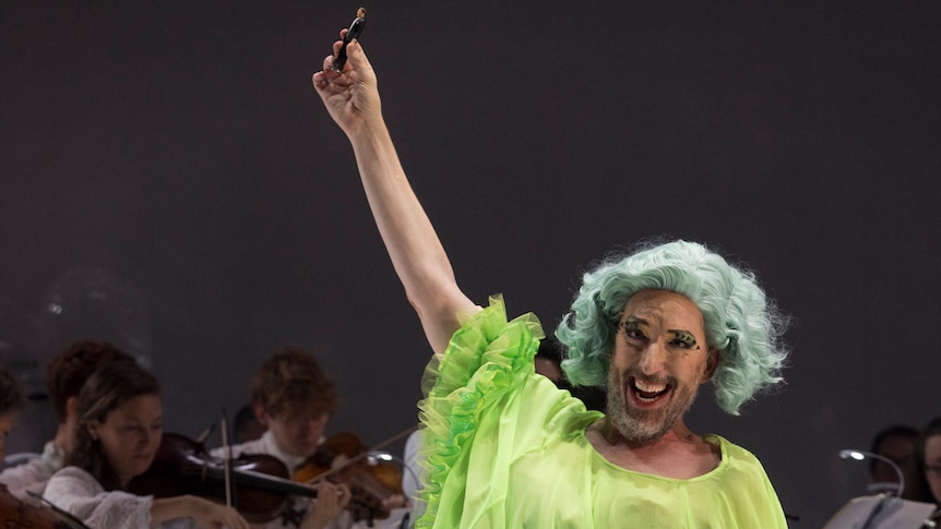 A bearded Kanen Breen in a wig and lime green gown in the title role of Rameau's Platée for Pinchgut Opera.
