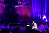 Nick Cave sits at the piano at Brisbane City Hall