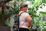 a woman wearing a sports backpack smiles at the camera