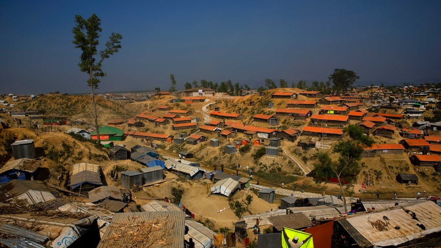 a Rohingya refugee hangs a blanket out to dry at Balukhali refugee camp