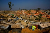 a Rohingya refugee hangs a blanket out to dry at Balukhali refugee camp