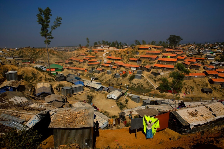 a Rohingya refugee hangs a blanket out to dry at Balukhali refugee camp