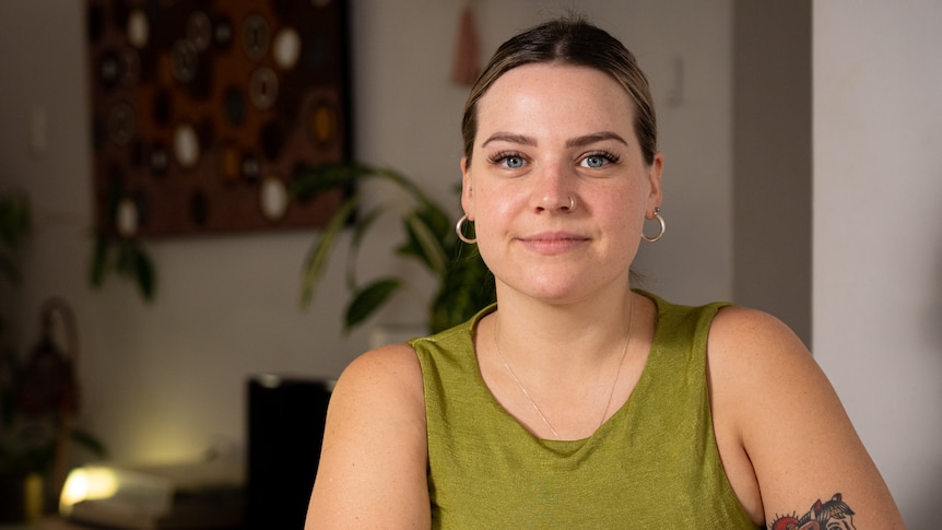 A woman in a green top sitting in her living room