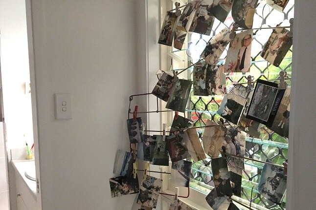 Photos are clipped to a window to dry after being damaged in Townsville flood.