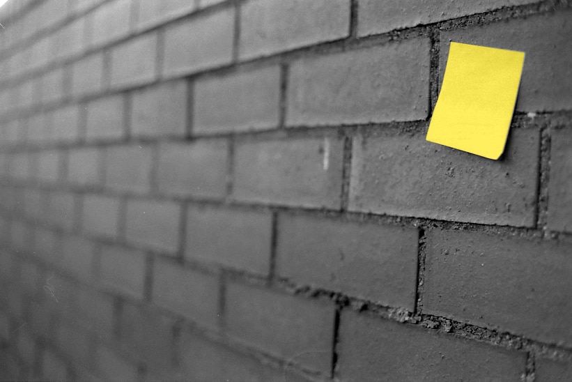 Sticky note on a brick wall