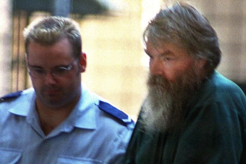 A man with a beard next to a police officer
