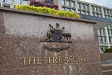 A sign says "The Treasury" with Australian coat of arms, outside an office building in Canberra.