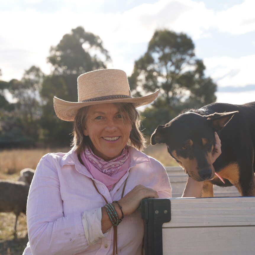 A photo of Rachael Treasure on her farm with her dog, Belle.