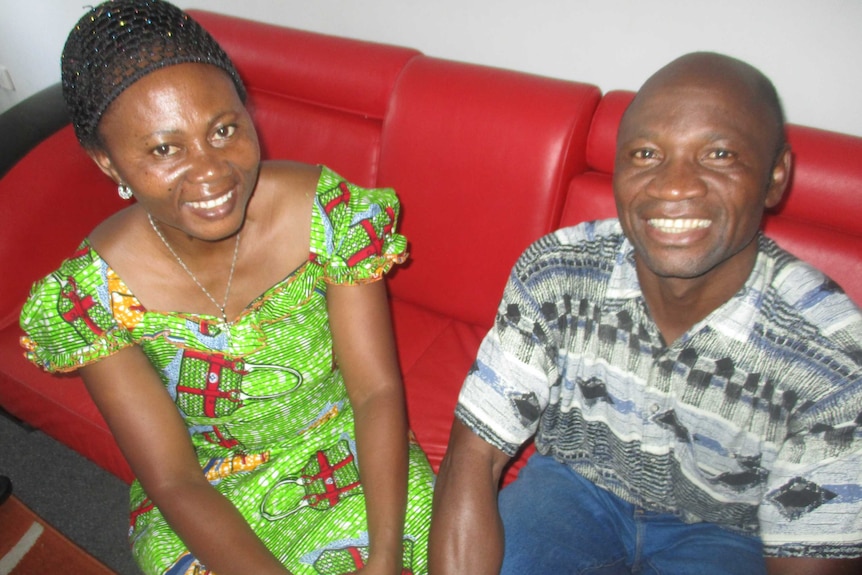 Washikala and Theophile Balebanga sit on a red couch.