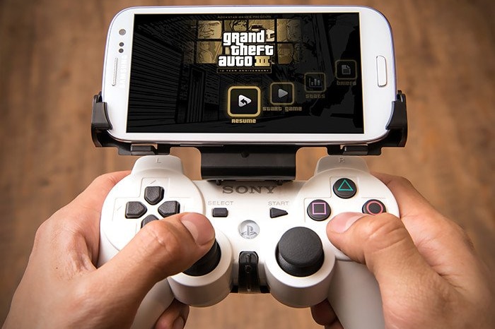 An adapter clips a PlayStation 3 controller onto an Android phone.