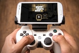 An adapter clips a PlayStation 3 controller onto an Android phone.