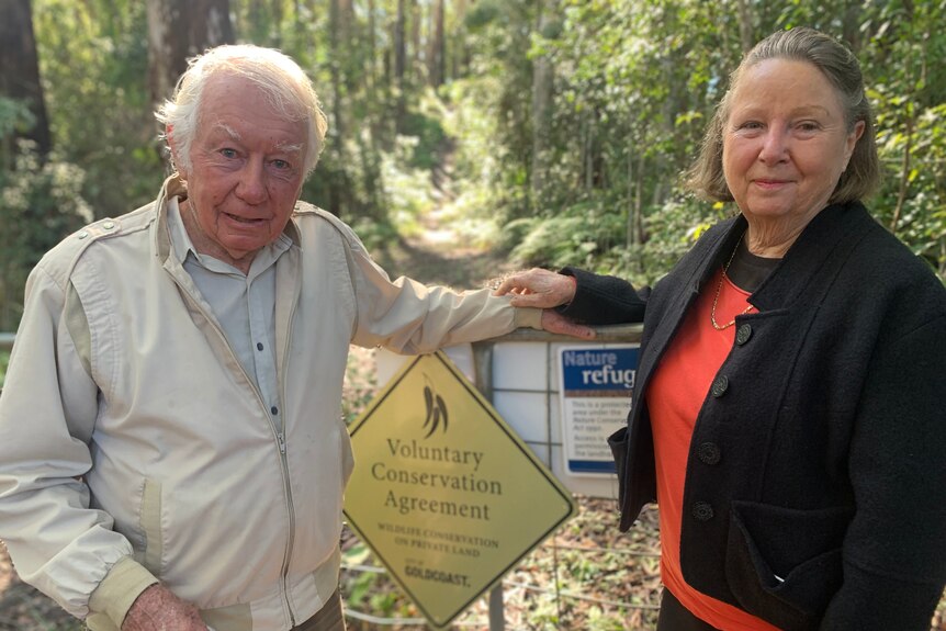 Man and woman standing next to 'voluntary conservation agreement' sign