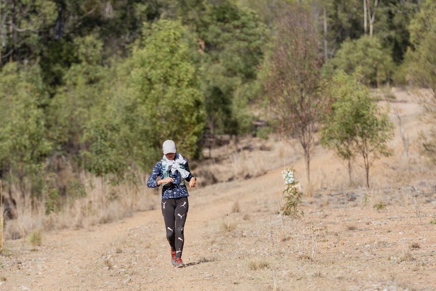 Jess runs along a rocky, dustry terrain in outback queensland