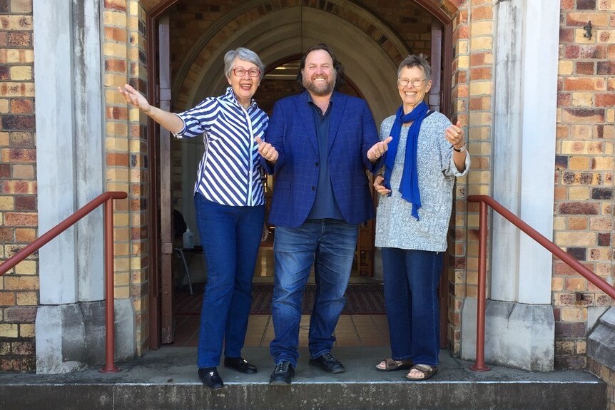 Ex-Mayor of Lismore Jenny Dowell OAM, Anglican Rev Christian Ford, and Sabina Baltruweit (L-R) outside church doors.