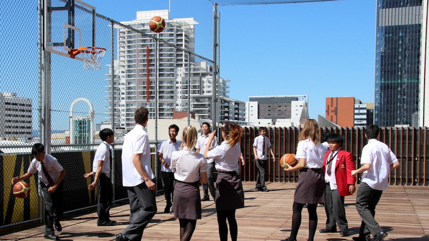 Students playing on the rooftop of their new high rise school