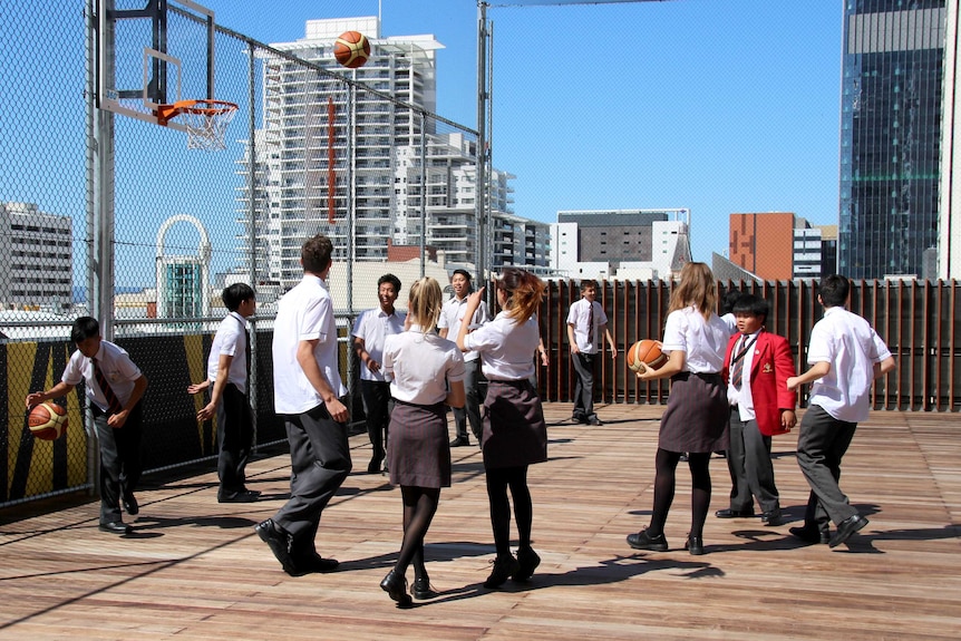 Students playing on the rooftop of their new high rise school