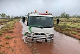 A truck bogged on a dirt road.