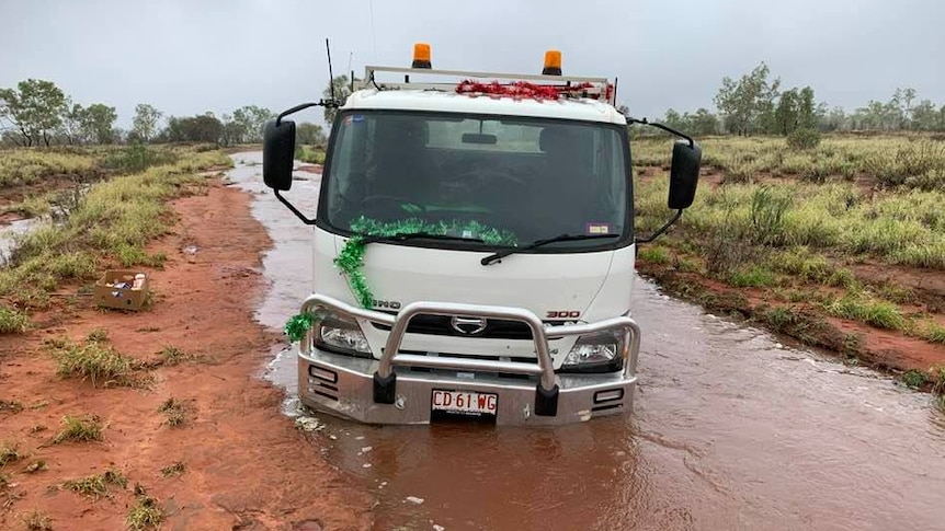 A truck bogged on a dirt road.