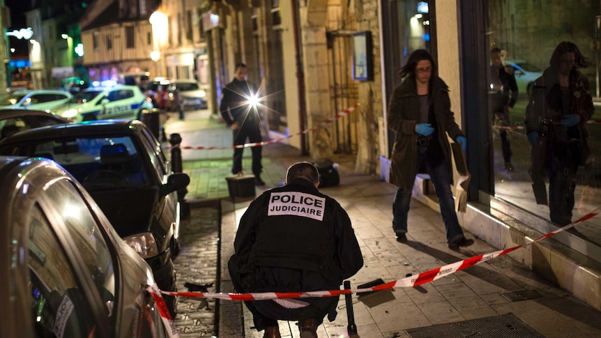 Police examine the site in Dijon where a driver ploughed into a crowd injuring 11 people.