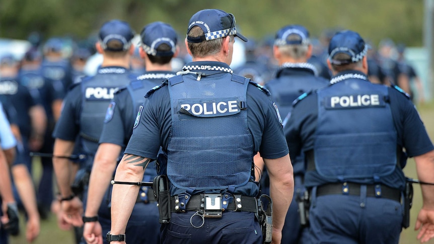 Police with their backs turned to the camera.