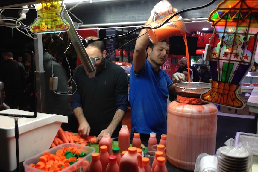 Stall holders prepare carrot juice at the Ramadan food festival in Lakemba
