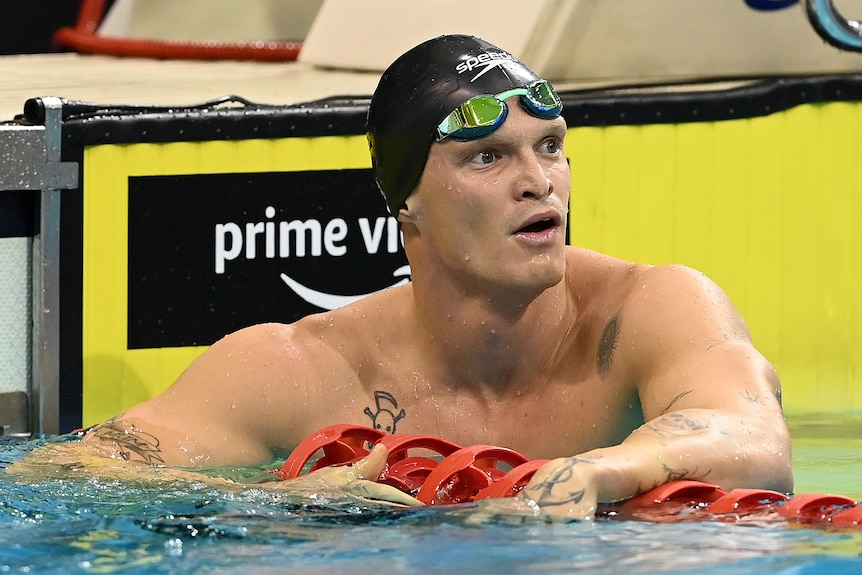 Cody Simpson holds on to a lane rope at the end of a swimming pool