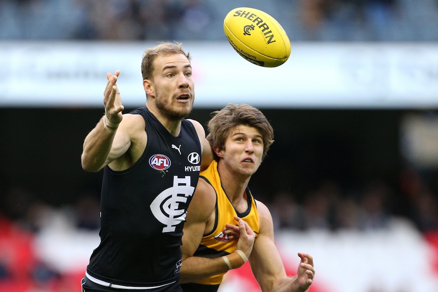 A Carlton AFL player attempts to take a mark with his right hand against Adelaide.