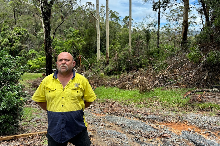 A man in a work shirt stands on his Gold Coast property