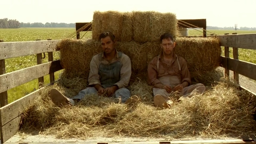 Still from O Brother, Where Art Thou? showing George Clooney and Tom Blake Nelson in the back of a truck.