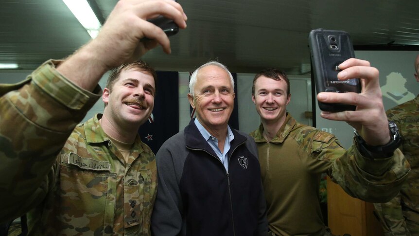 Prime Minister Malcolm Turnbull takes selfies with Australian troops in Iraq