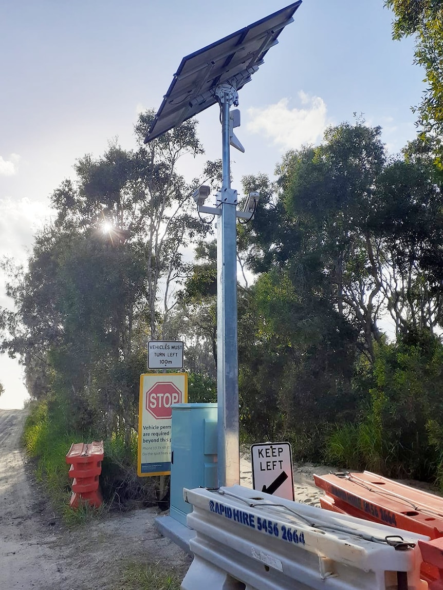 Cameras on a pole at the entrance to a beach.