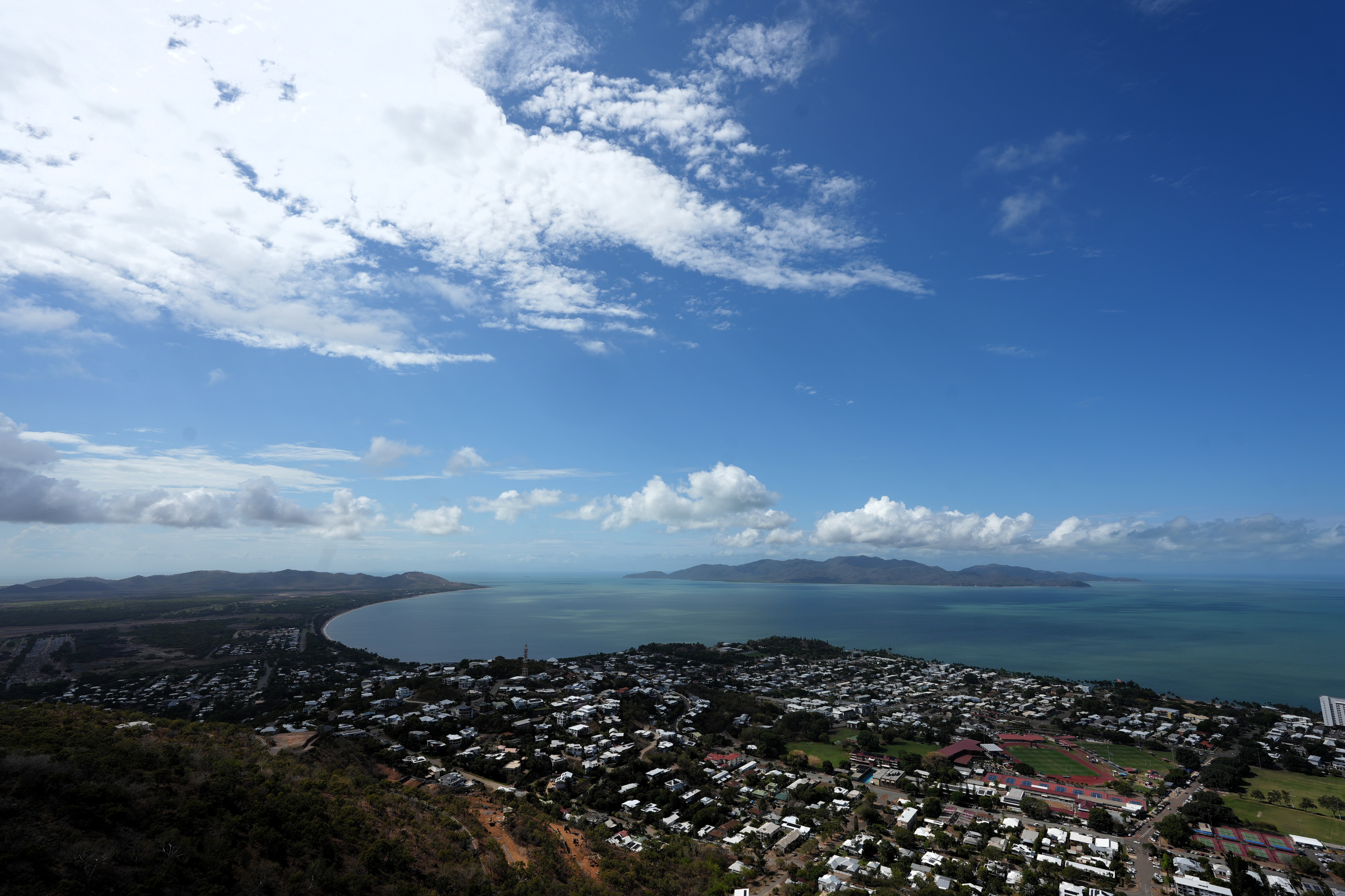 An elevated view of the Townsville coastline on a partly cloudy day.