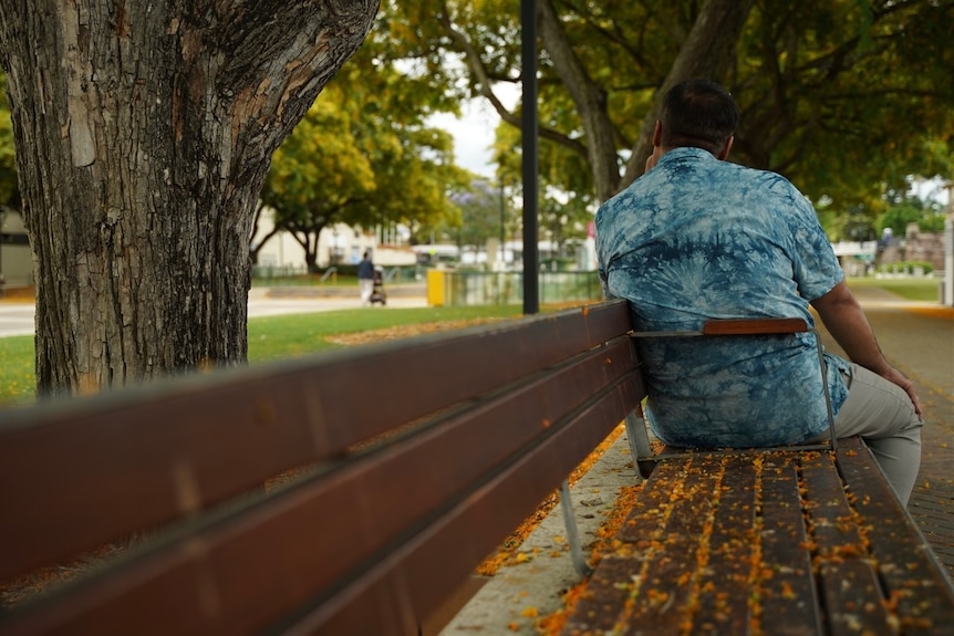 Abdul facing away from camera on a park bench