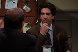 A scene from Friends, with David Schwimmer's character Ross sitting at a table in mid-conversation.