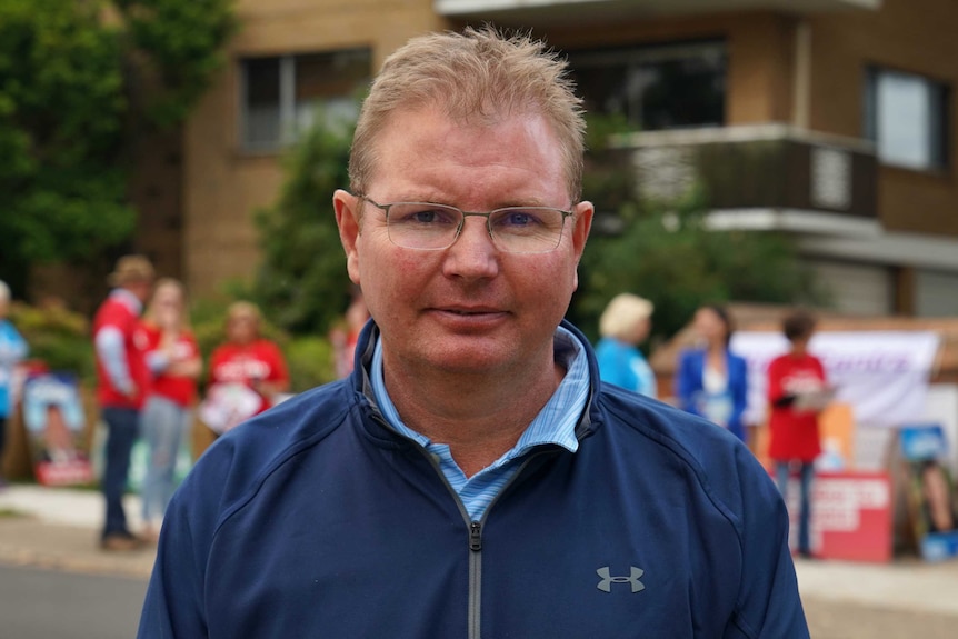 Mr Laundy stands in front of a group of political campaigners.