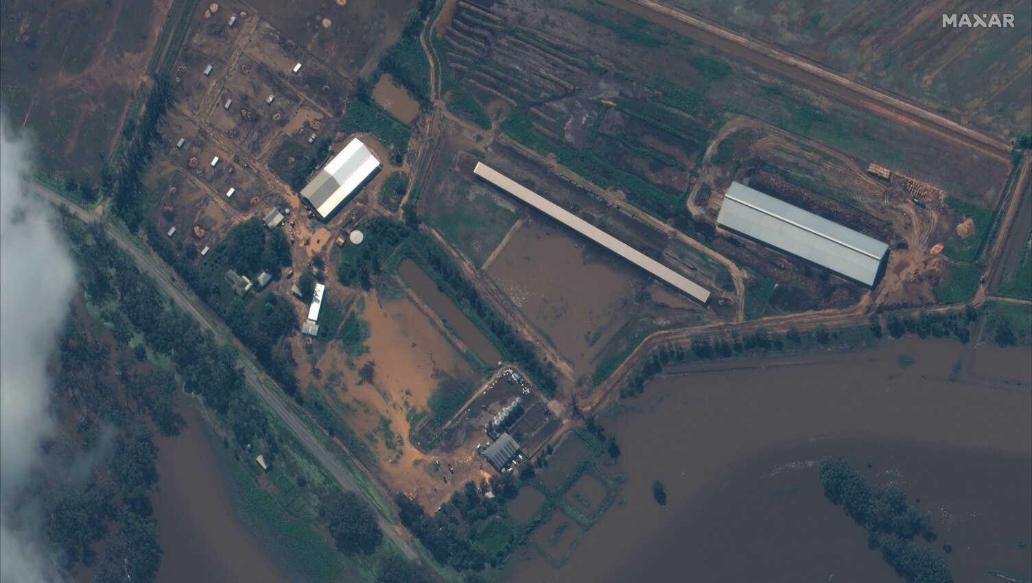 A picture from above of a farm under brown floodwater 