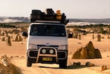 A van drives through Pinnacles Desert