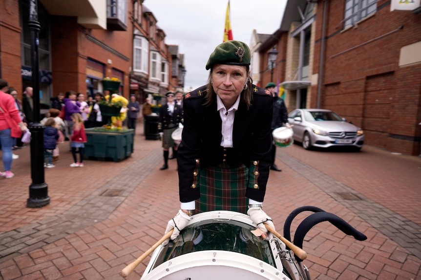 A man with a marching band drum.