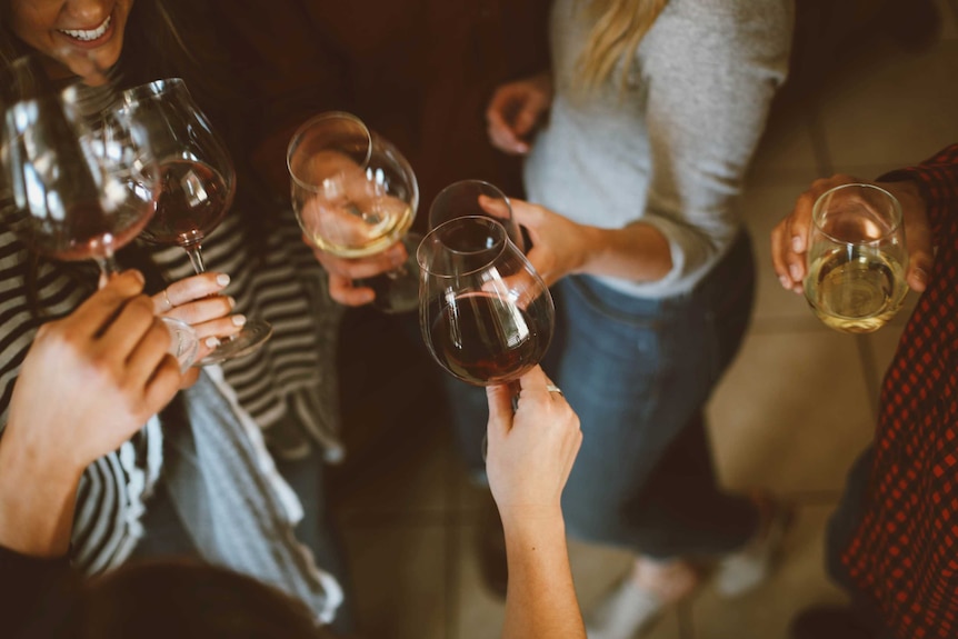 People standing around holding glasses of wine